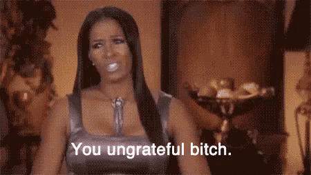 a woman is sitting in front of a vase and says `` you ungrateful bitch '' .