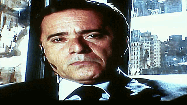 a man in a suit and tie with headphones on
