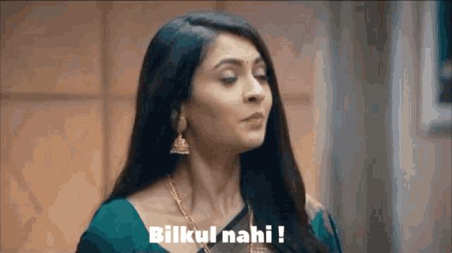 a woman in a green saree is making a funny face and saying bilkul nahi !