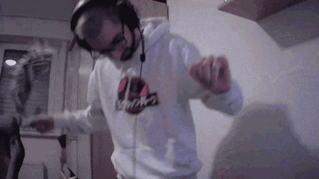 a man wearing headphones and a sweatshirt that says ' jurassic park ' on it is dancing