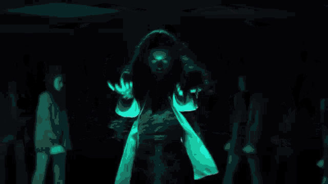 a woman in a white jacket is dancing in front of a group of men in suits