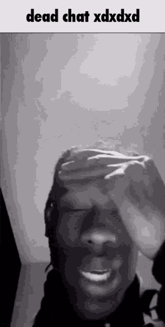 a black and white photo of a man covering his face with his hand and the words dead chat xdxdxd .
