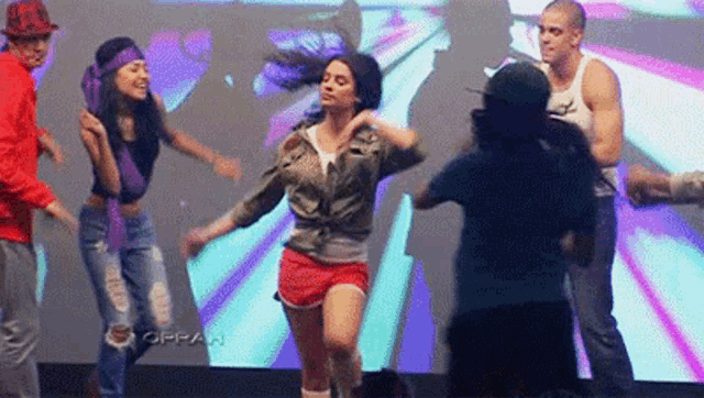 a group of people are dancing in front of a screen that says oppa