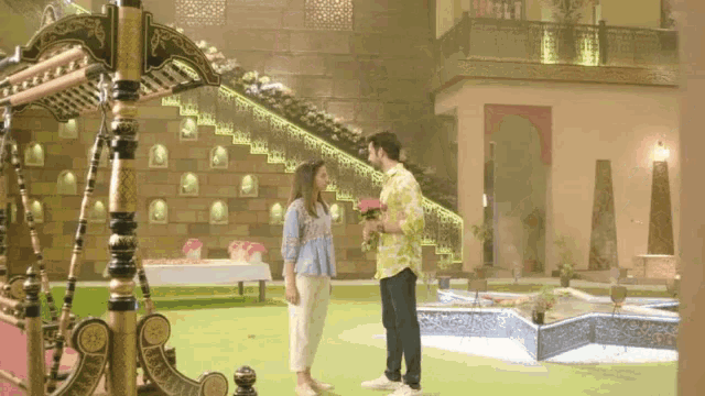 a man is giving a woman flowers in front of a staircase
