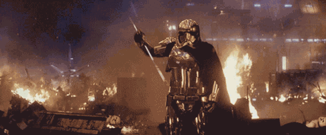a storm trooper holding a sword in front of a burning building