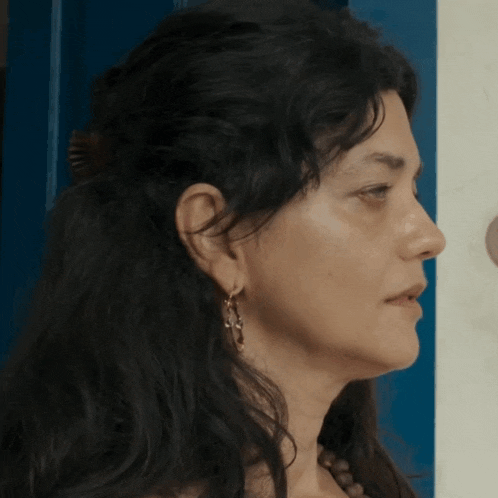 a close up of a woman 's face with a blue door behind her