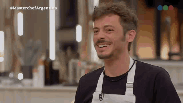a man in an apron is smiling in front of a masterchef argentina logo