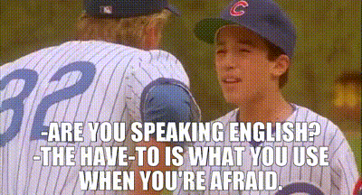 a baseball player wearing a cubs hat is talking to another baseball player .