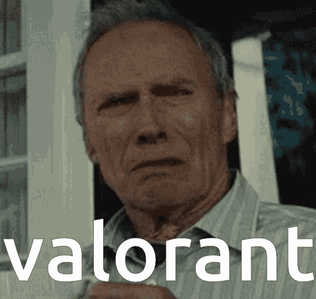 a man in a striped shirt is standing in front of a window with the word valorant on the bottom