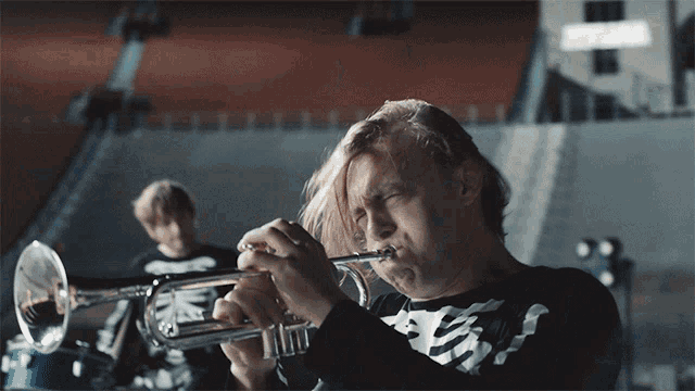 a man in a skeleton shirt plays a trumpet in a band