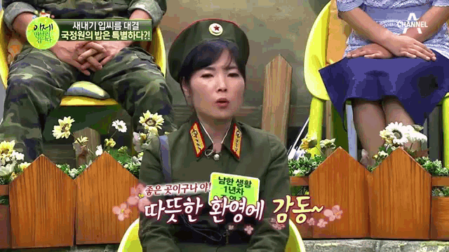 a woman in a military uniform sits in a chair with a sign that says channel on it