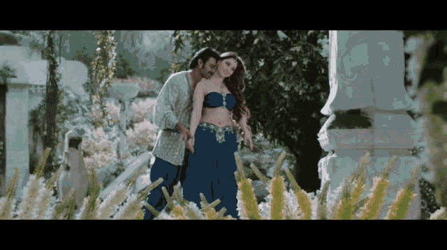 a man and a woman are hugging in a field of flowers