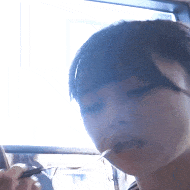 a close up of a woman eating with a fork in her mouth