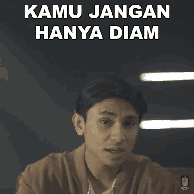 a young man says kamu jangan hanya diam while looking at the camera
