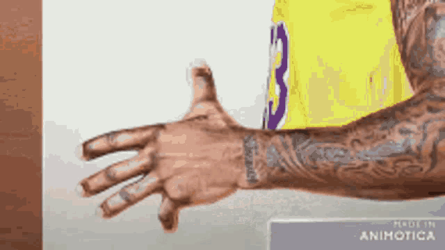 a man with a tattoo on his arm is wearing a yellow jersey with the number 3