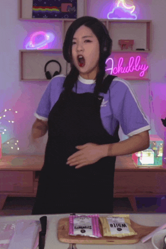 a woman in a purple shirt is standing in front of a sign that says chubby