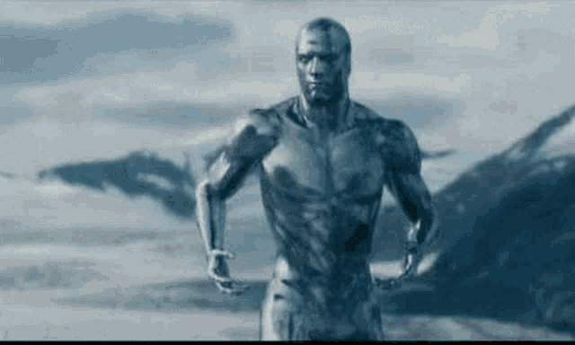 a statue of a man in a superhero costume is running in the snow .