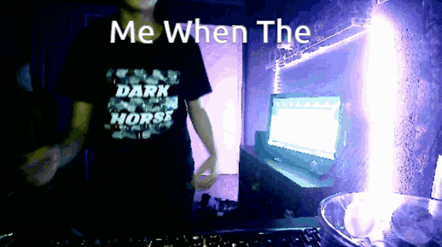 a man wearing a dark horse shirt is dancing in front of a computer