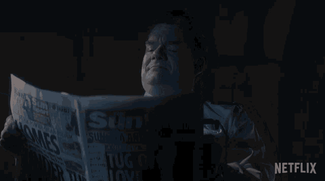 a man is reading a newspaper that says the sun on it