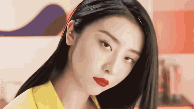 a close up of a woman 's face with red lipstick and a yellow shirt