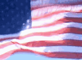 an american flag is waving in the wind with a blue sky in the background
