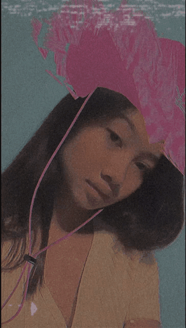 a girl wearing a pink hat with a purple cord around her neck