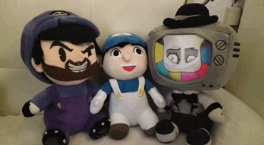 three stuffed toys are sitting next to each other including a tv head