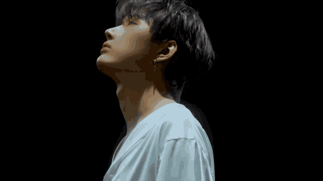 a close up of a man 's face with his eyes closed and a white shirt on