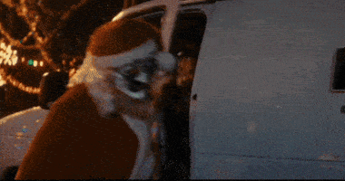 a man dressed as santa claus is standing in front of a van that says side on it