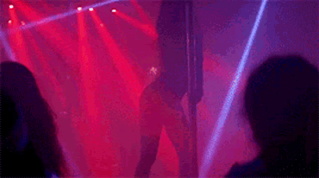 a woman dancing on a pole in front of a crowd