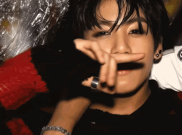 a close up of a person 's face with a big hit logo in the corner