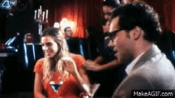 a man and a woman are sitting at a table with a martini in front of them and a sign that says 3rd