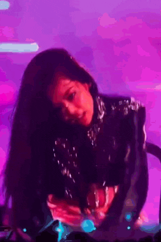 a woman is dancing on a stage in front of a crowd .