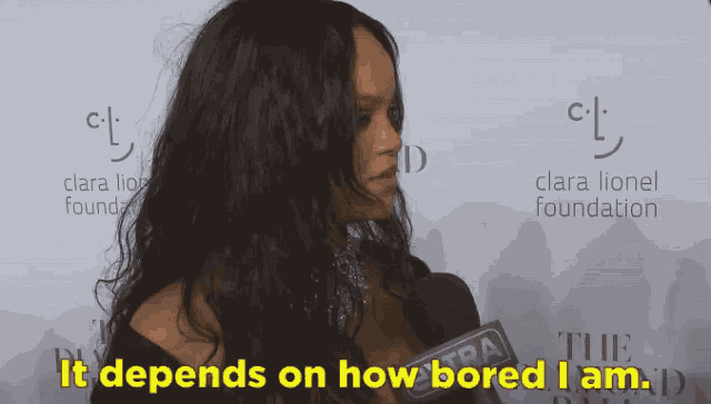a woman with long hair is talking into a microphone and says it depends on how bored i am