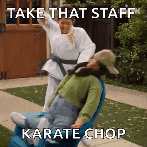 a woman in a karate uniform is pushing a woman in a wheelchair .