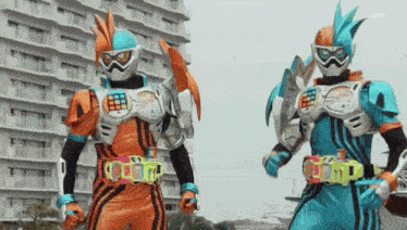 two kamen riders are walking in front of a building .
