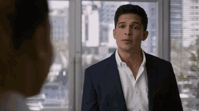 a man in a suit and white shirt is looking at another man