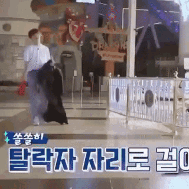 a man is walking down a hallway in front of a sign that says ' dragon ' on it