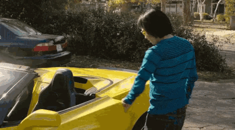 a man is standing next to a yellow sports car