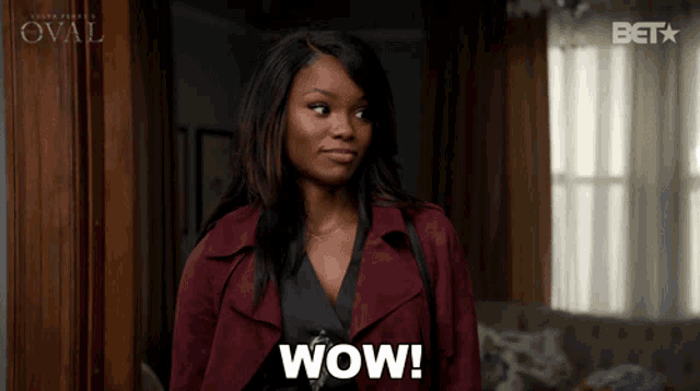a woman wearing a maroon coat says wow