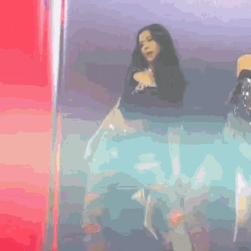 a woman is standing on a stage in front of a red light .