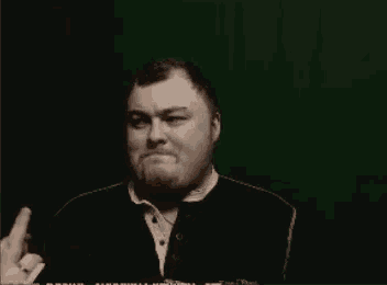 a man is giving the middle finger in front of a green screen