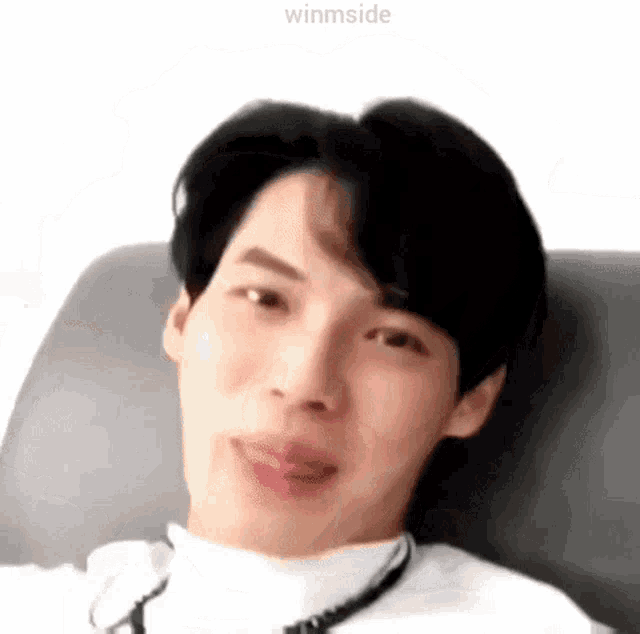 a close up of a person 's face while sitting on a couch making a funny face .