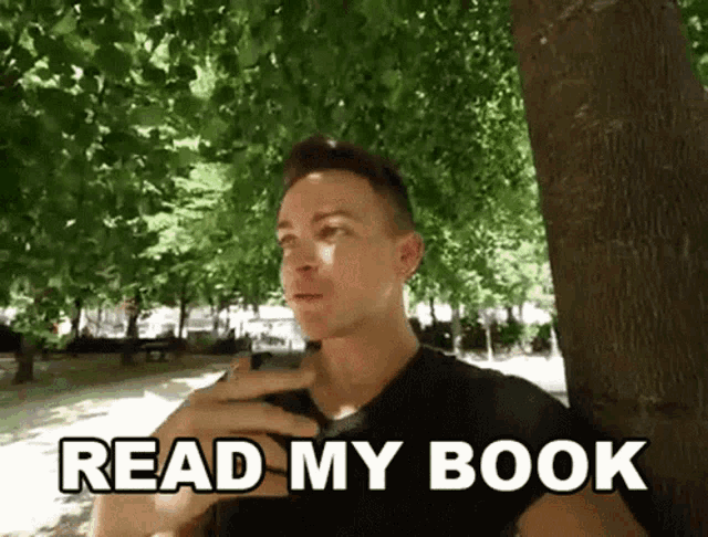 a man leaning against a tree with the words read my book written below him