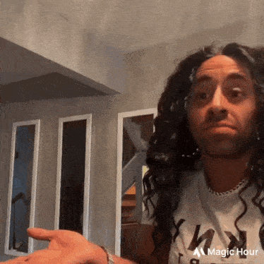 a man with long curly hair is wearing a white shirt with the word ny on it
