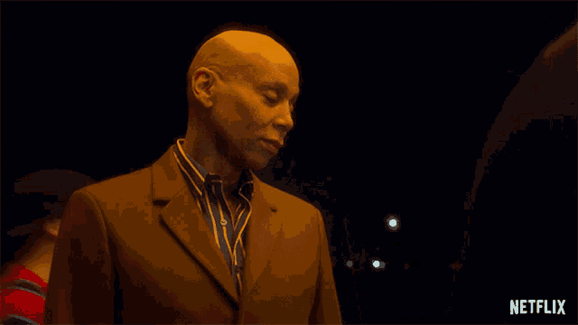 a man in a suit is standing next to a netflix logo