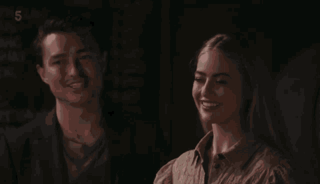 a man and a woman sitting next to each other with the number 5 on the bottom left