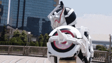a white robot with a horn on the back is standing on a sidewalk