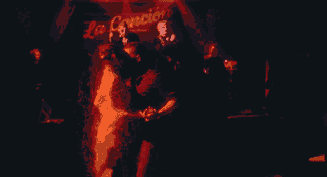 a group of people dancing in front of a sign that says " la cancion "