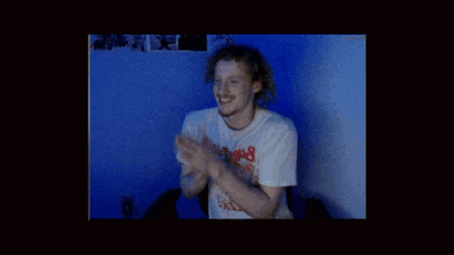 a man in a white shirt stands in a dark room